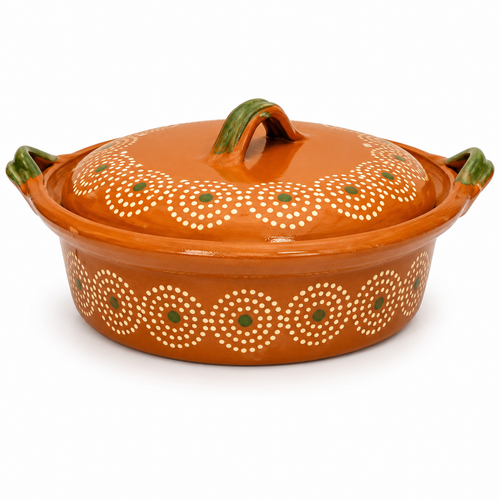 An orange glazed ceramic casserole dish with a matching lid, decorated with white circular dot patterns and small green accents, set against a plain white background.