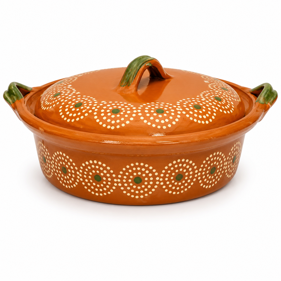 An orange glazed ceramic casserole dish with a matching lid, decorated with white circular dot patterns and small green accents, set against a plain white background.
