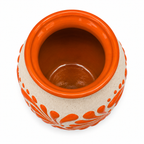 A ceramic pot with a glossy orange glazed interior and rim, featuring a speckled beige exterior decorated with orange leaf-like patterns and small dots, shown from a top-down view on a white background.