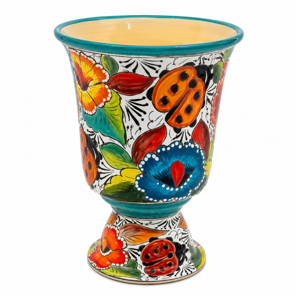 A hand-painted ceramic planter pot with a footed base, decorated with vibrant floral and ladybug motifs on a white background.