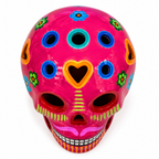 A vibrant pink skull with colorful floral and geometric Day of the Dead style decorations, shown on a plain white background.