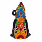 A hand-painted ceramic dog figurine decorated with vibrant, traditional Mexican Talavera-style patterns in blue, red, orange, green, yellow, and black on a white background.