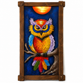 A framed metal wall art piece depicting a colorful owl perched on a branch against a deep blue night sky with a glowing orange sun. The artwork is housed in a rustic dark brown wooden frame with corner brackets, shown against a plain white background.