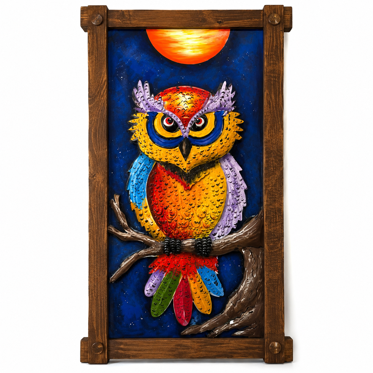 A framed metal wall art piece depicting a colorful owl perched on a branch against a deep blue night sky with a glowing orange sun. The artwork is housed in a rustic dark brown wooden frame with corner brackets, shown against a plain white background.