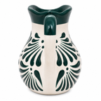 Ceramic pitcher with green floral patterns on a white background